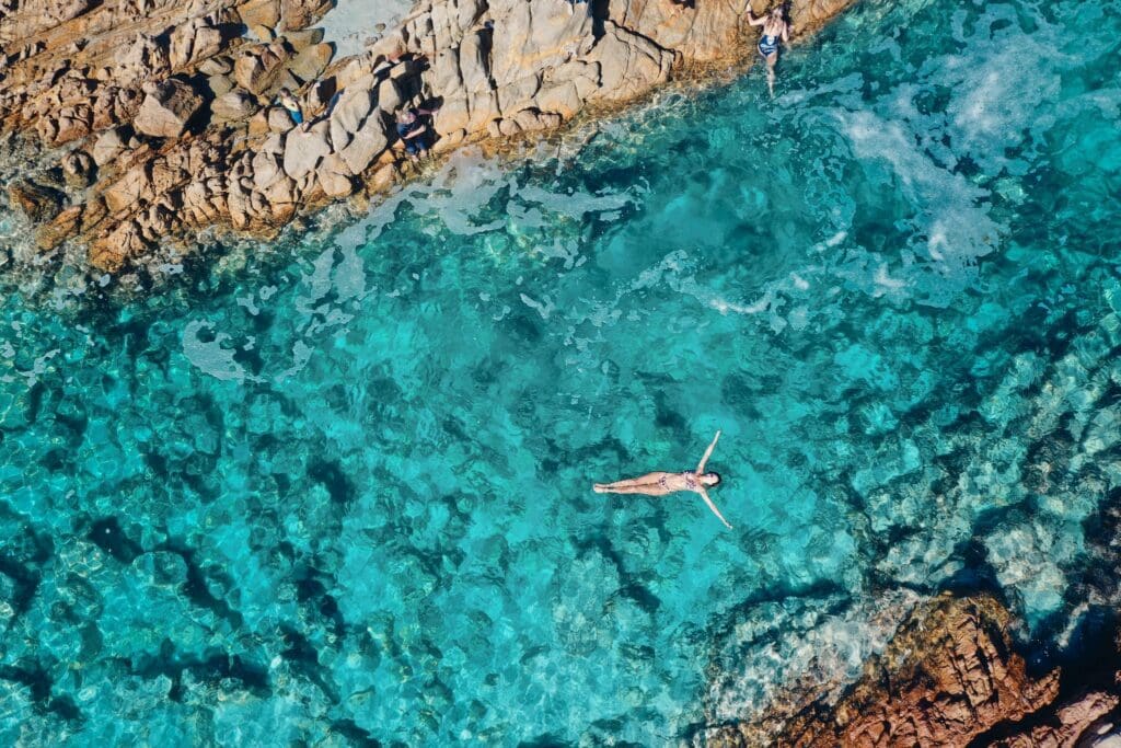 A woman in a bikini floating in the channel of aqua blue water