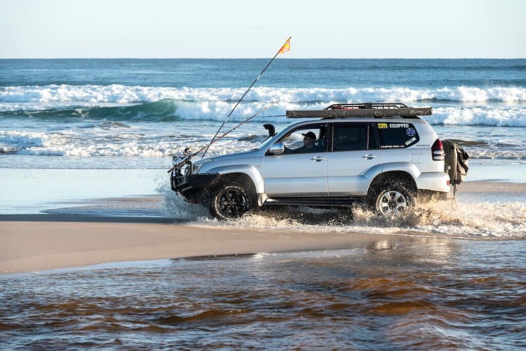 An off-road vehicle cruises along the water of one of many 4WD Beaches in the south west.